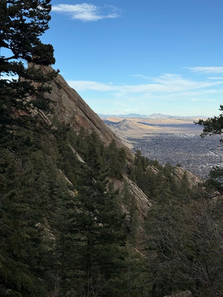 Looking down towards town from just below the arch. Flatiron rising up to the left, foot hills fading in the distance at the middle, and town in the upper right corner. 