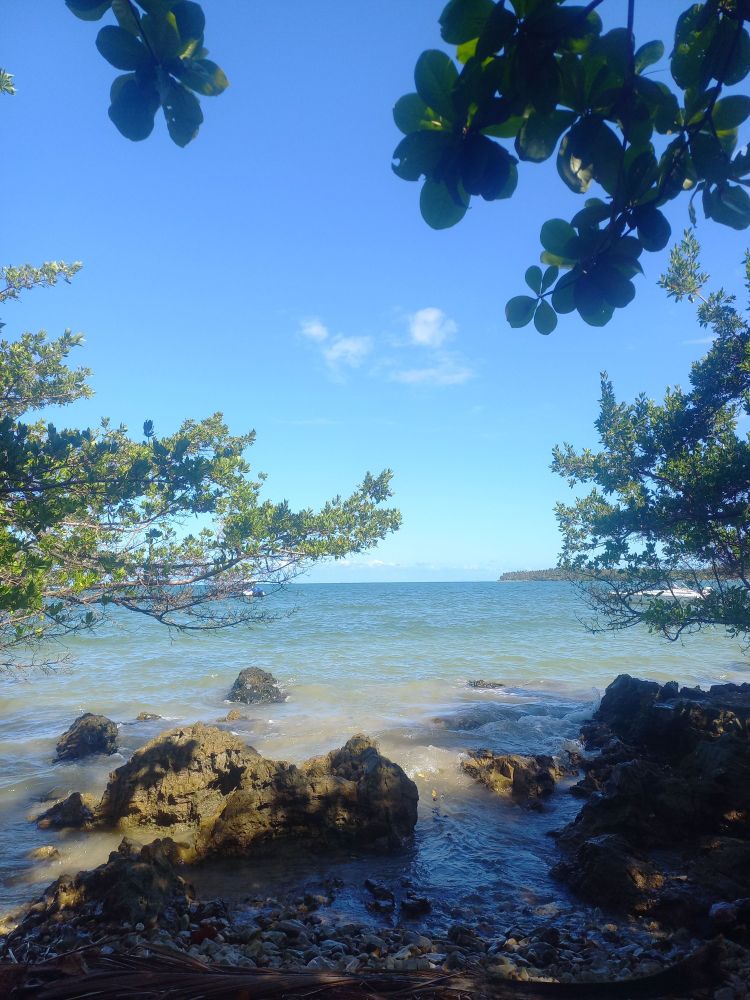 foto de uma praia linda, com a água calminha, azul clara.