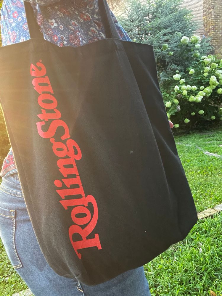 Sunshine highlighting a black bag that says Rolling Stone in red script for the magazine.