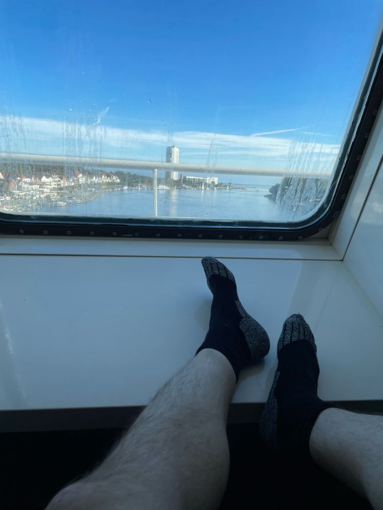 Blick aus einem Fenster eines Schiffs, auf der Fensterbank meine Füße