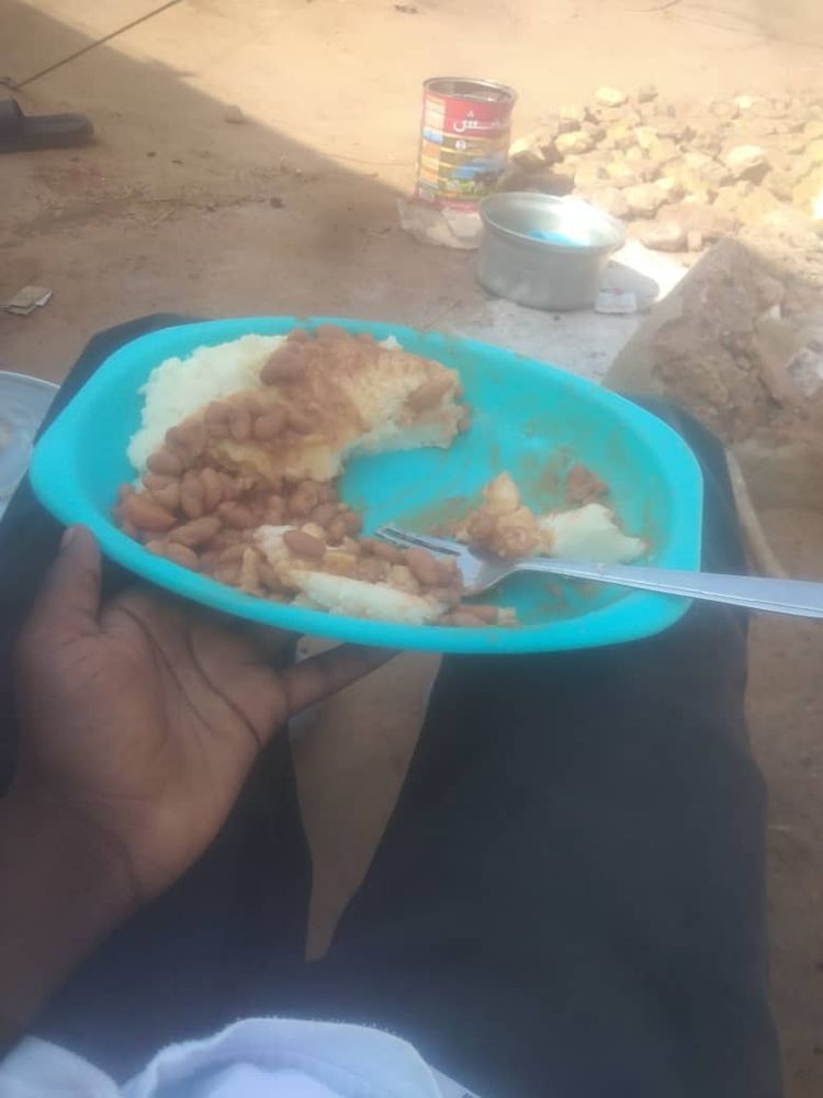 A photo of a bowl of food containing beans and potatoes.