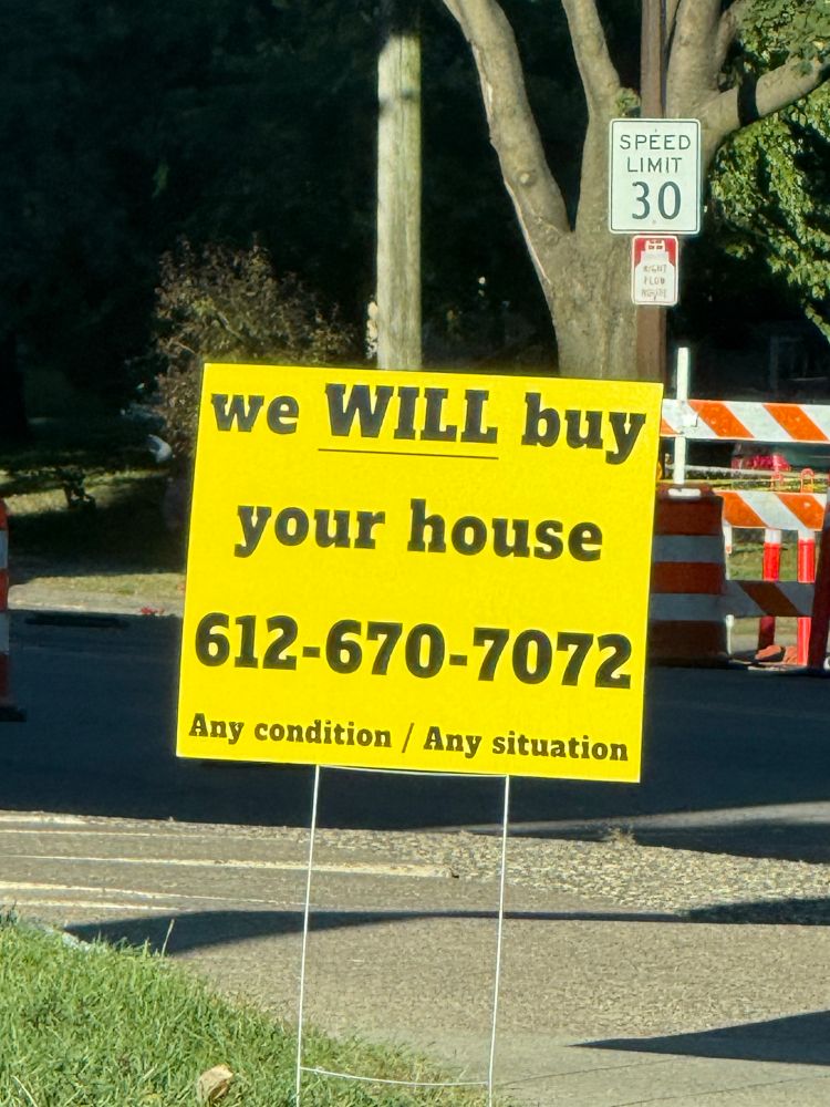 A yellow yard sign that says we will buy your house with the will underlined