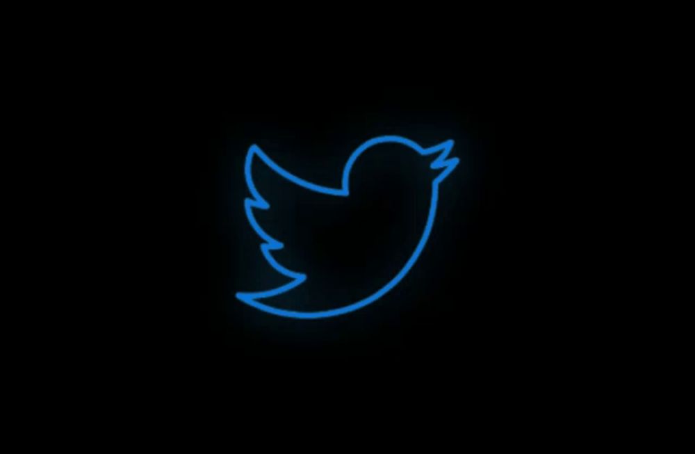 a twitter logo that is blue and glowing in the dark