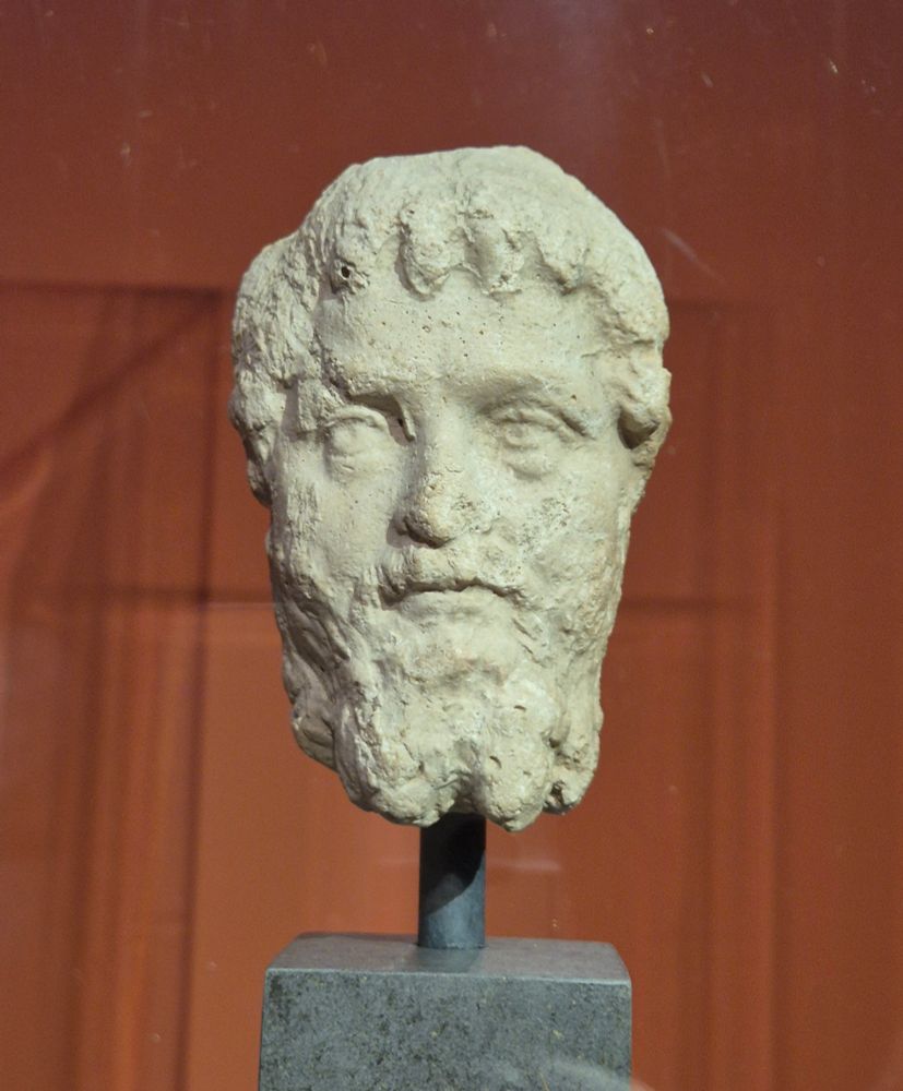 Front view of the portrait of Septimius Severus, made of yellowish plaster, mounted on a stone cube as a base. 