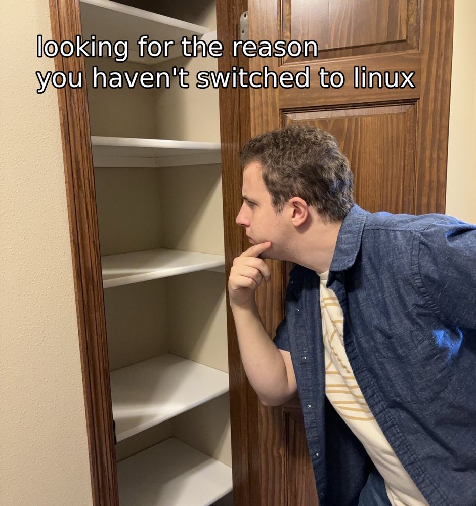 A photo of a man looking into an empty closet with the caption “looking for the reason you haven’t switched to linux”