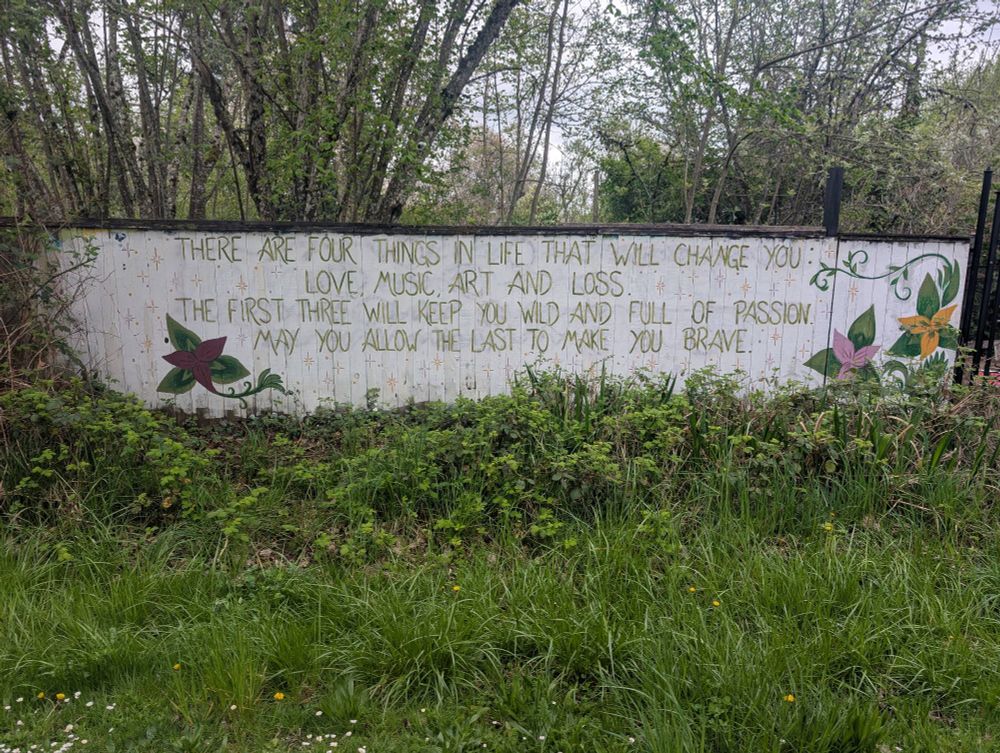A wall with text that reads, "There are four things in life that will change you: love, music, art and loss. The first three will keep you wild and full of passion. May you allow the last to make you brave."