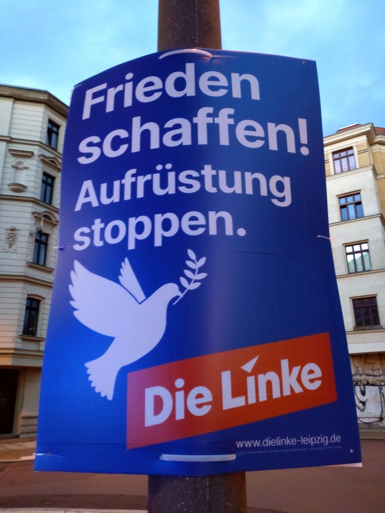 Wahlplakat, Die Linke. Weise Schrift und Friedenstaube, auf mittelblauem Hintergrund.
"Frieden schaffen!
Aufrüstung stoppen."