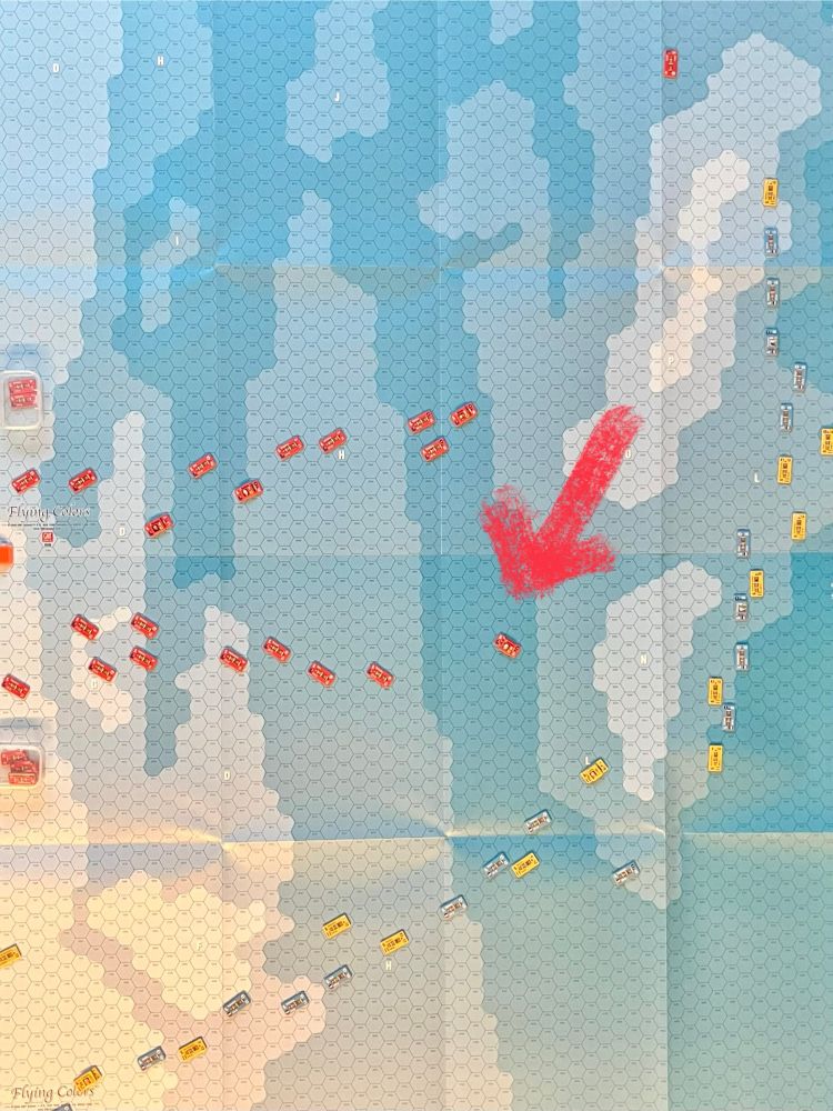 On a paper ocean covered in hexes, red counters representing British ships lunge towards blue and yellow counters representing French and Spanish ships at the Battle of Trafalgar. 

A big red arrow has been drawn on the image to point out where Admiral Collingwood is. 