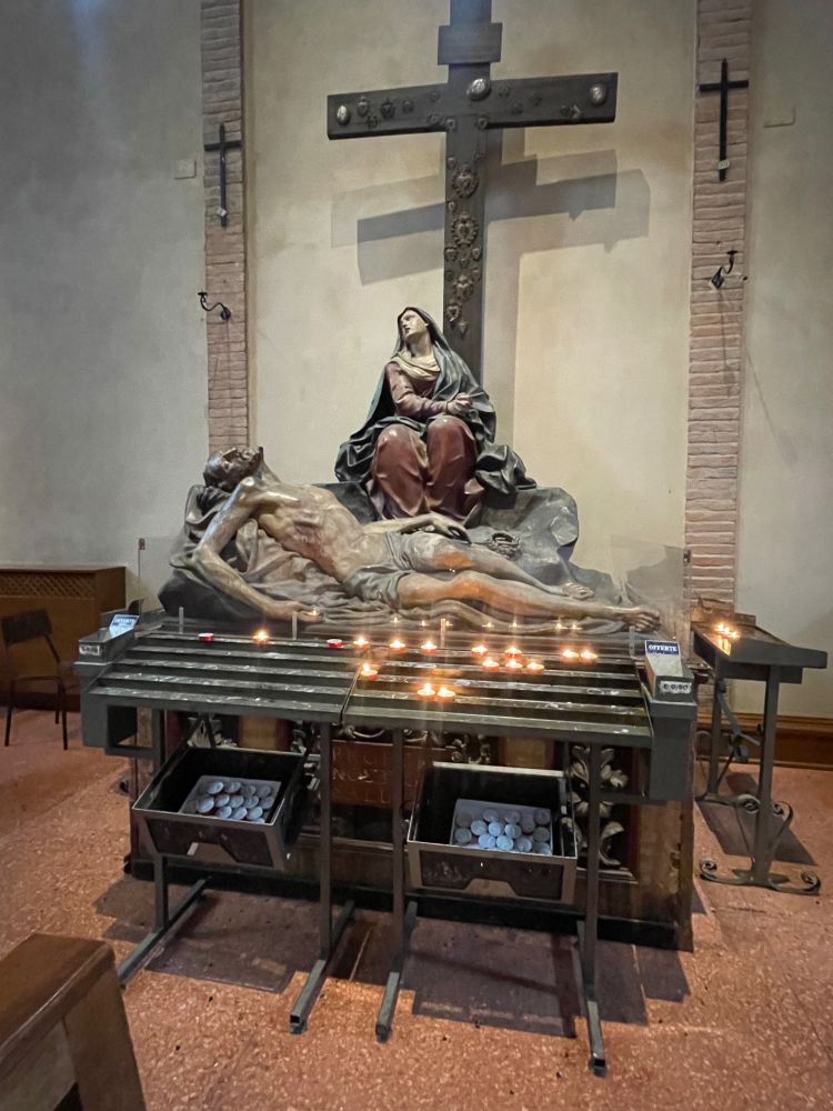 Sculpture of the death of Christ in a Bologna church, with candle offerings 