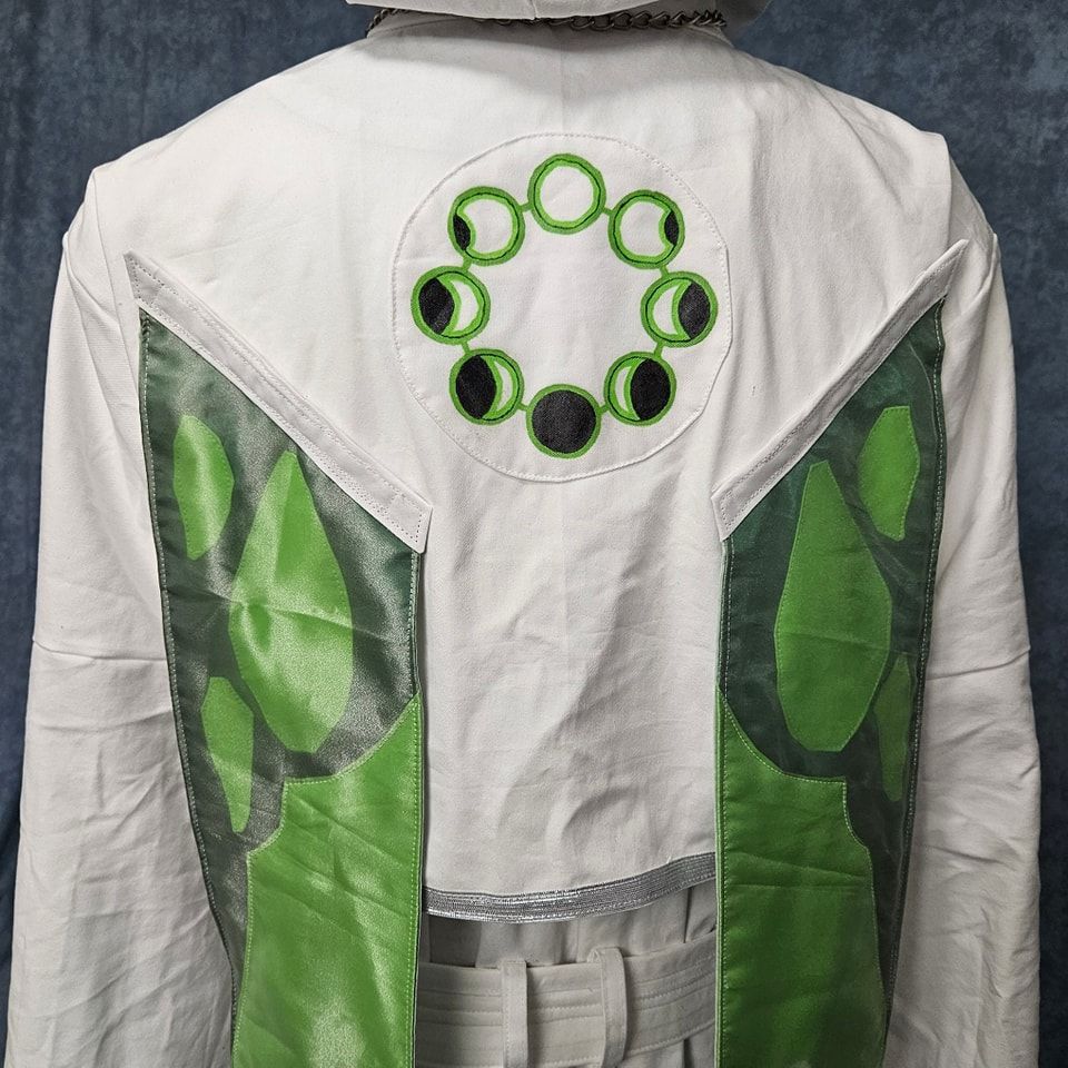Costume upper back close up depicting handpainted black and acid green moon phase design and part of the acid and darker green moth wings.