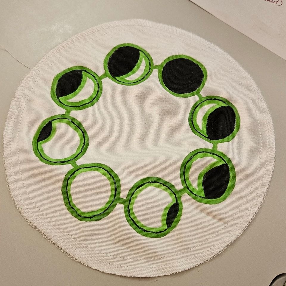 Moon phases in black, white, and acid luna moth green in a joined beadlike circle. This is part of the custom order shown in progress.