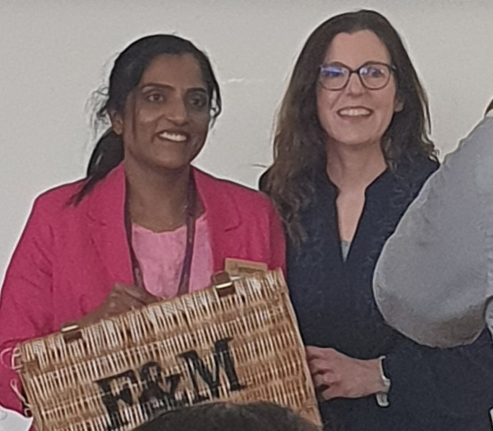 A picture of Dr Aiswarya Girija (Ash) receiving a thank you for her work coordinating the organisation if Monogram2025.