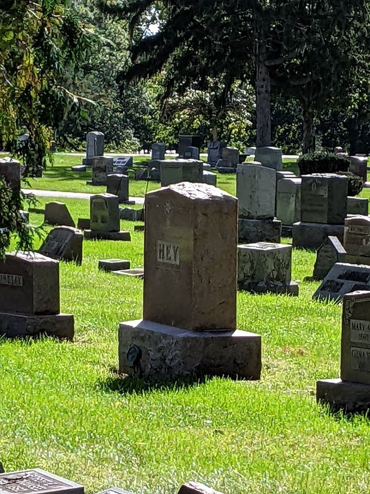 In a graveyard, one tall headstone reads simply, "Hey"