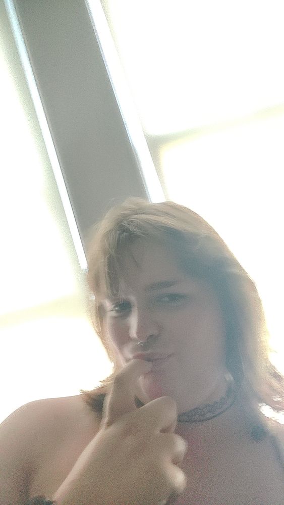 selfie of me, a voluptuous white tgirl, doing a cheeky lil face