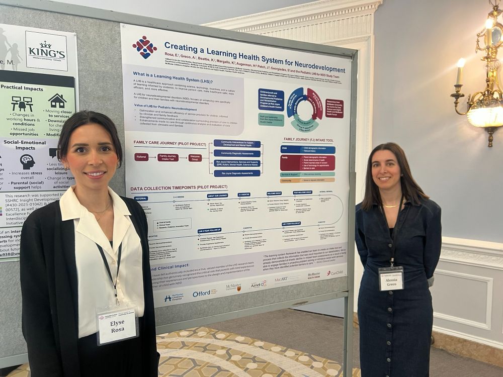 Dr. Elyse Rosa and Alessia Greco stand and smile next to their poster.