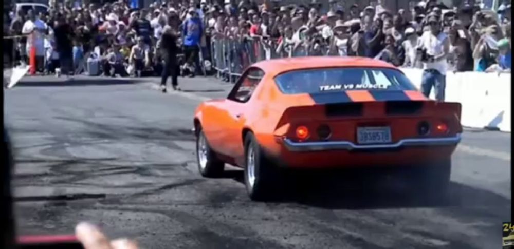 an orange car with the word team on the windshield