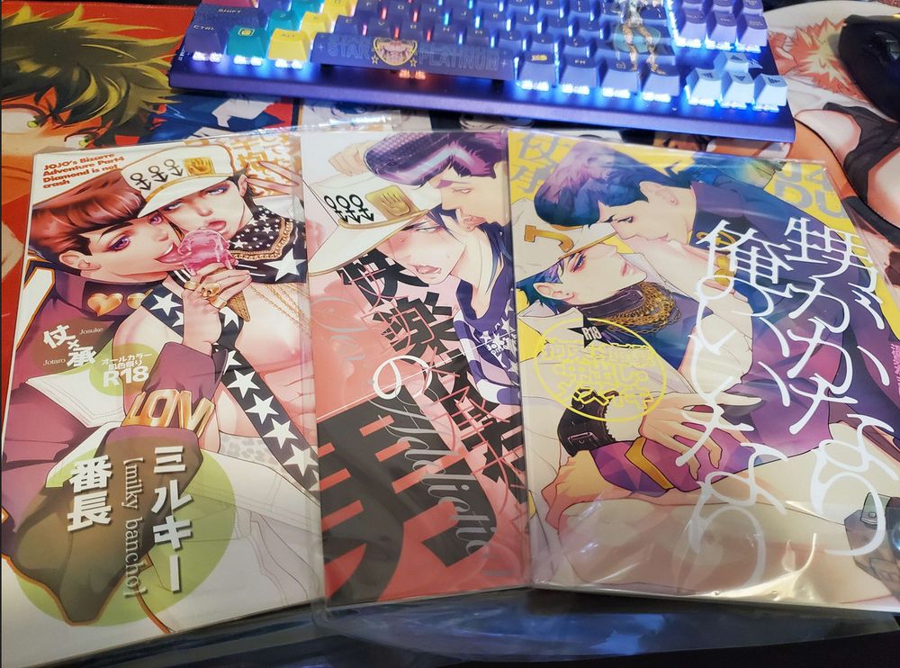 Photo of three of Kirumi's doujins (Onsen Namaniku Geisha, Shouchikubai Q-shuu). Left to right: "Nephew is pretty good to me", "A man with a pleasure dependence", and "Milky Bancho".