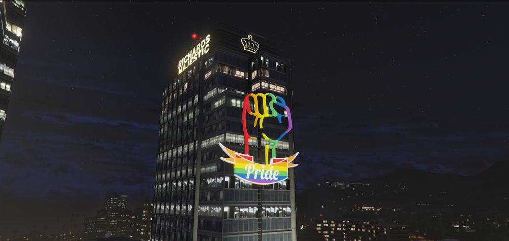 Ein Screenshot aus GTA 5.

Zu sehen ist der obere Teil eines Wolkenkratzers. Auf der Seite sind Neonröhren in Form einer nach oben gereckten Faus in Regenbogenfarben zu sehen.

Darunter zu sehen ist eine Prideflagge mit dem Wort Pride.