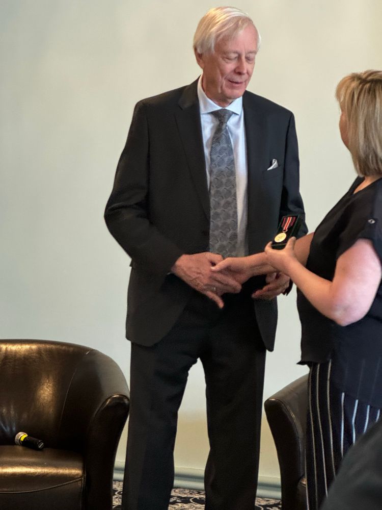 Jerry Bigam receiving his King Charles IIII Coronation Medal from Melissa Secord of Canadian Celiac Association. 