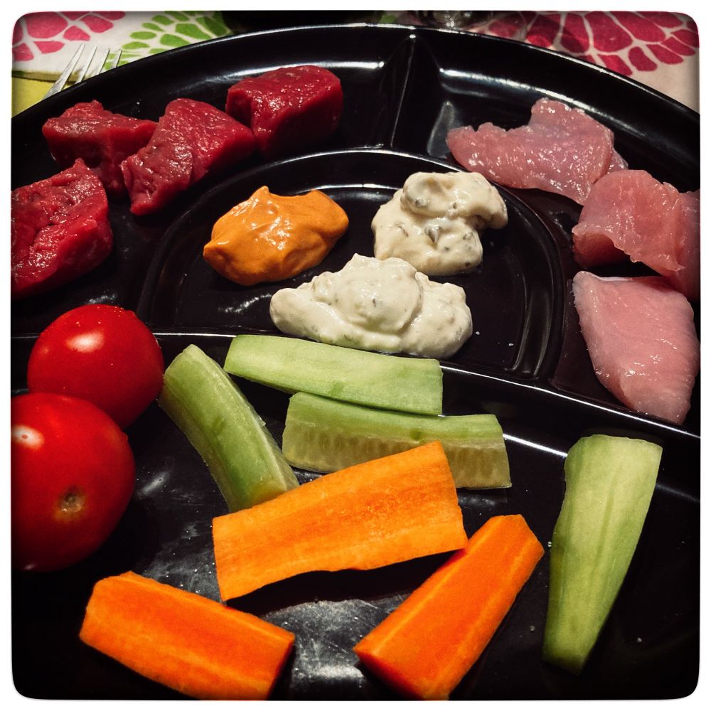 Assiette de viandes, légumes et sauces pour une fondue bourguignonne