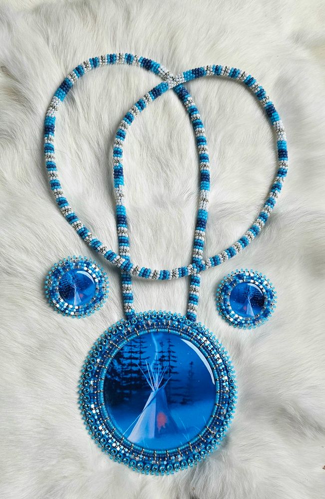 Beaded medallion and earring set on white rabbit fur.