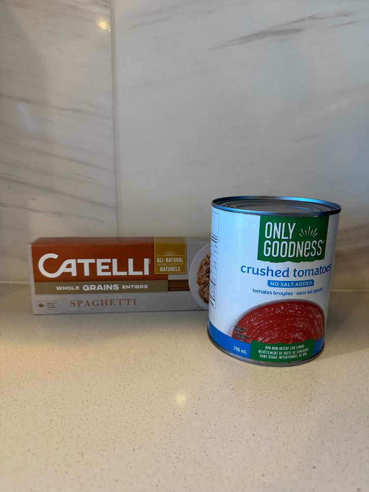 Watch: we have the ingredients. This image is a can of crushed tomatoes and a package of dry spaghetti noodles. 