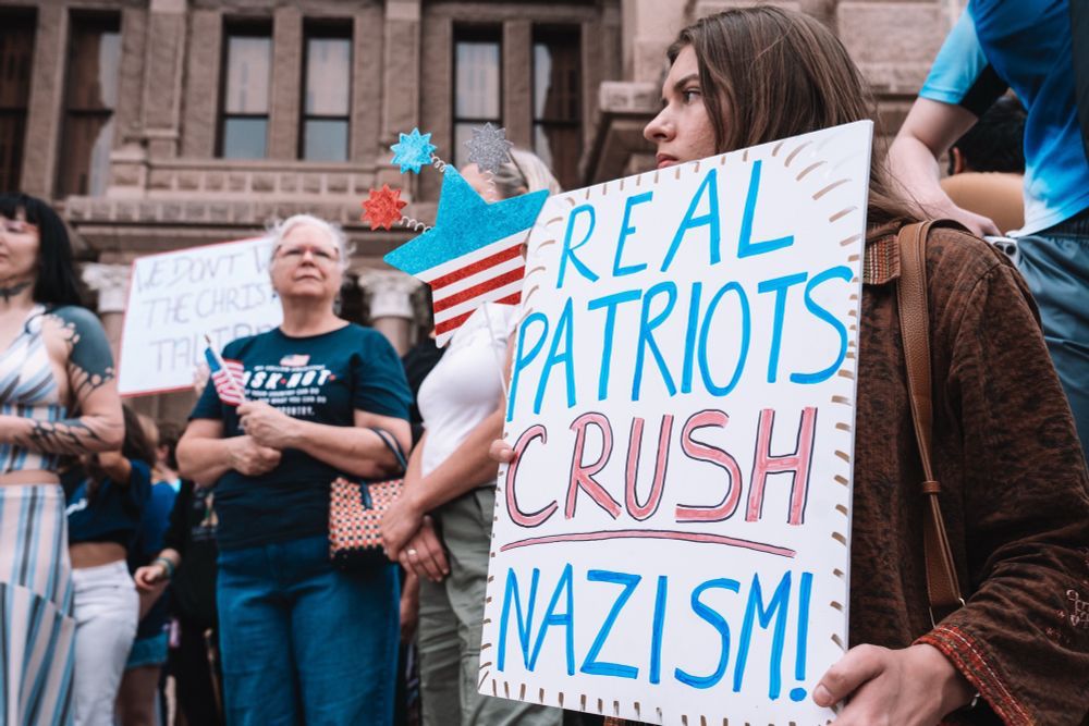 A sign says “real patriots crush nazism"