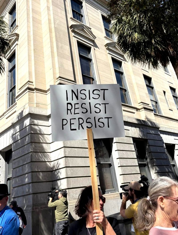 A handwritten sign that says: Insist. Resist. Persist.