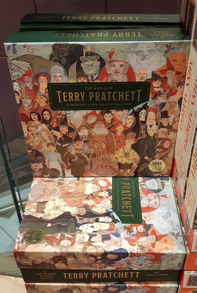 A pile of jigsaw puzzles featuring all the Discworld characters, by Paul Kidby.