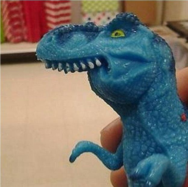 Une figurine de dinosaure, genre t-rex, bleu (!) et sans mâchoire inférieure.
