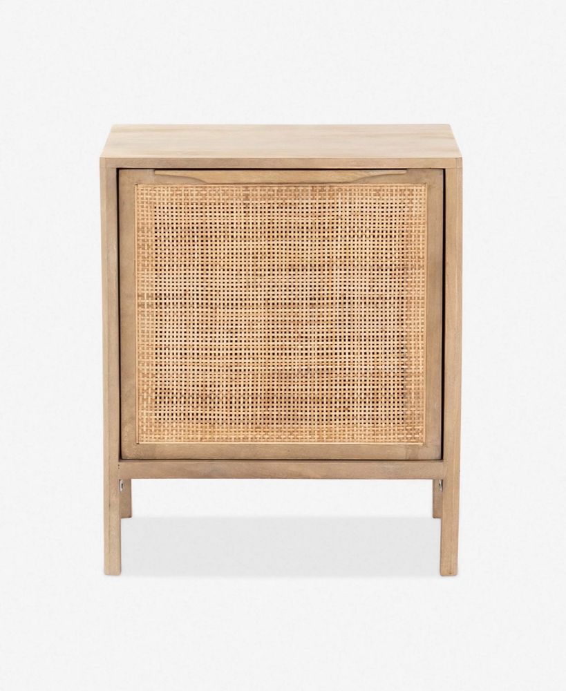 Picture of “the Hannah” nightstand from Lulu and Georgia. It is a light wood square nightstand with skinny straight legs. The front door is a wicker or woven rattan type material. 