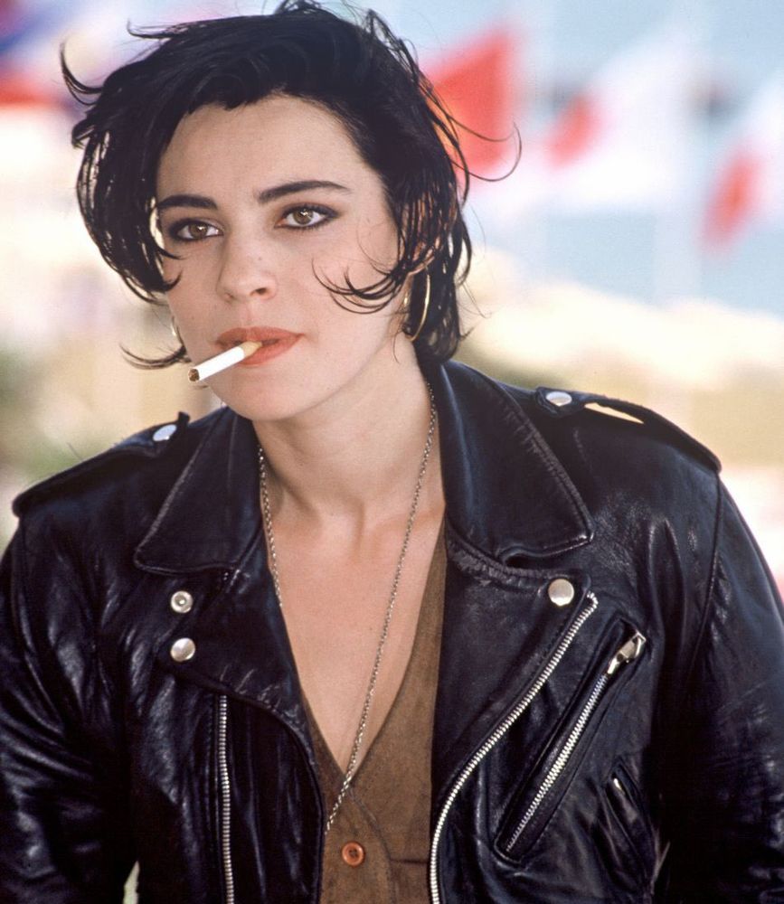 French Actress Béatrice Dalle enjoying a cigarette at Cannes Film Festival in 1988 while wearing a leather jacket
