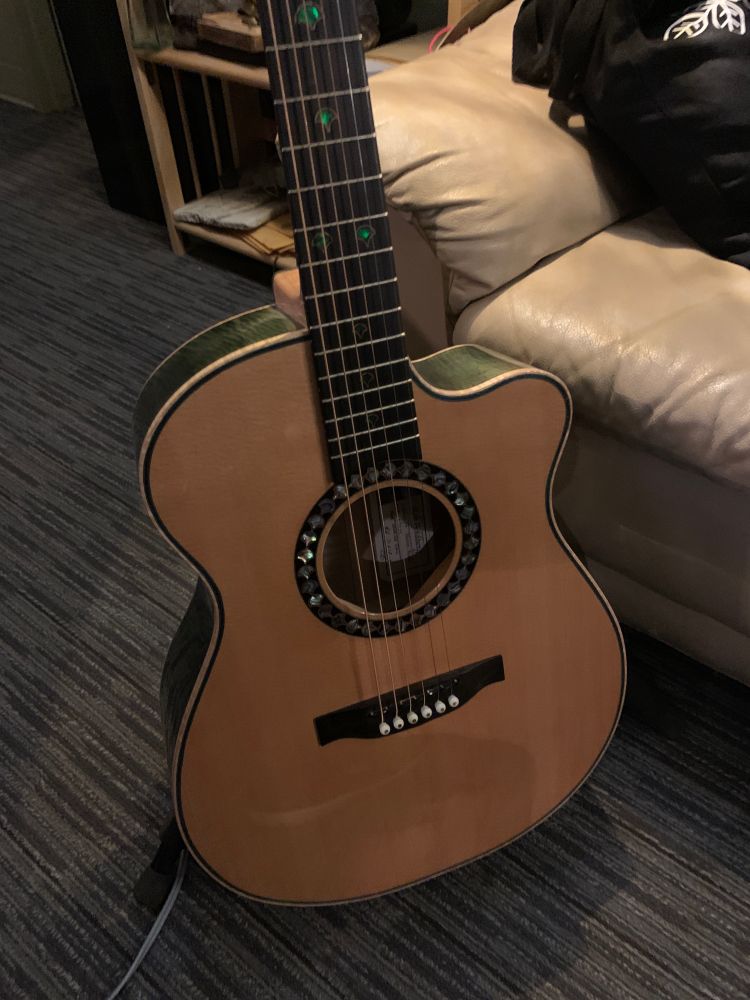 Photo of acoustic guitar on a rack in the studio.