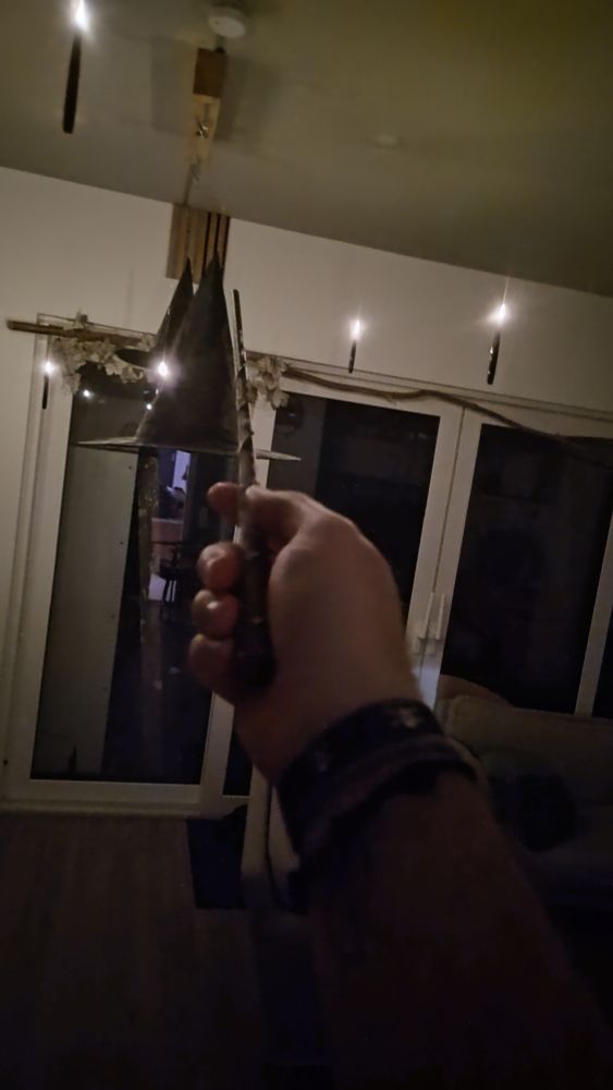 Einen Zauberstab in einer Hand.
Damit werden im Hintergrund dargestellte schwebende elektronische Kerzen angeschaltet.