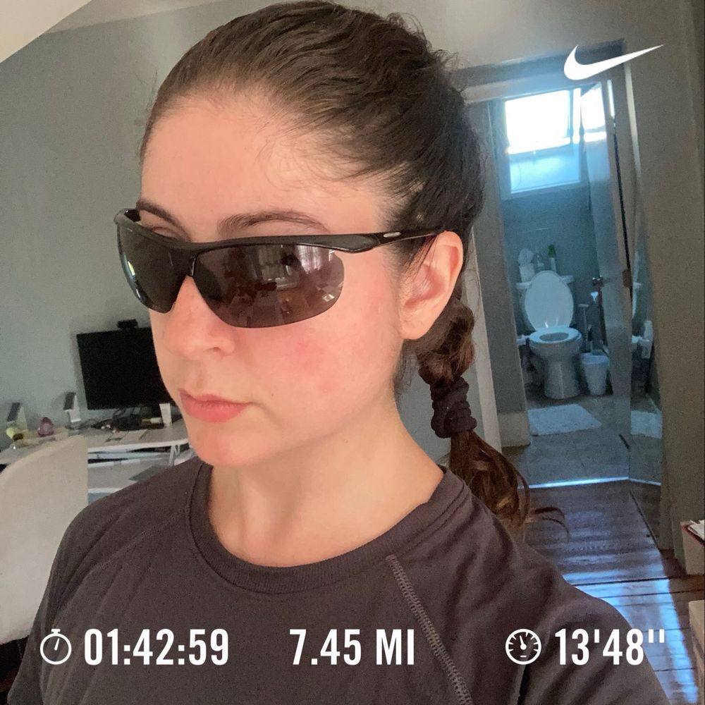 Selfie of a woman with dark sunglasses and a braid with text overlay: 1 hour 42 minutes, 7.45 miles, and average pace 13’48”.