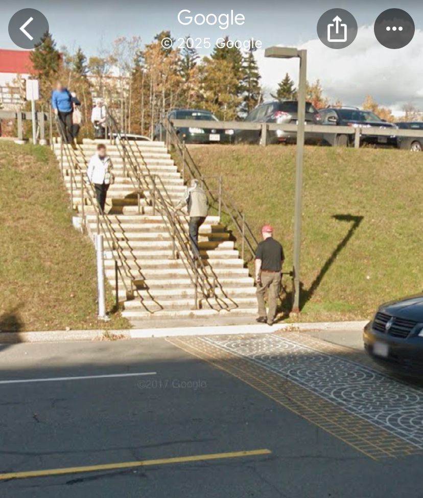 Steep hill (about 45 degrees) with approximately 20 steps going up to a raised parking lot