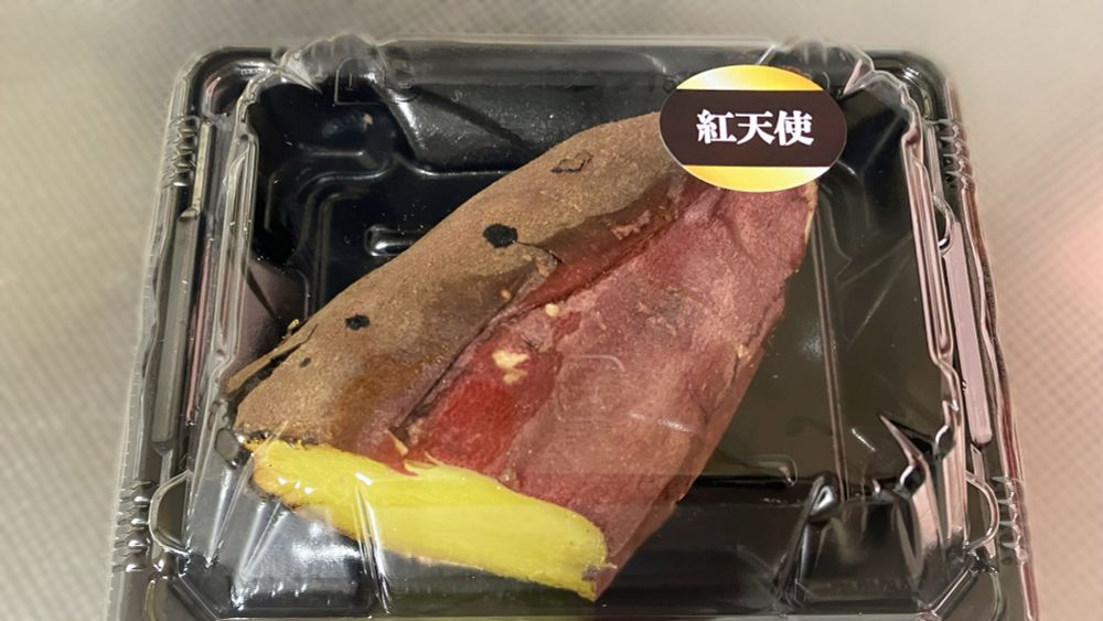 焼き芋1/2カットが透明なふたのパックに入っている。ふたには「紅天使」と書かれたシールが貼ってある。