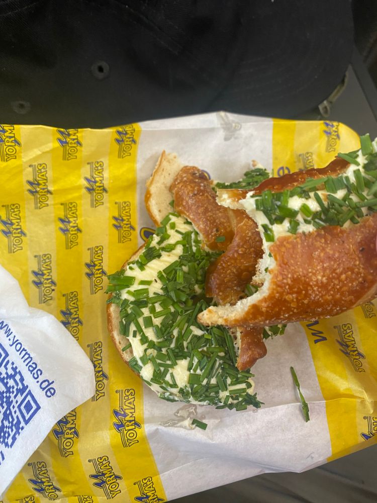 Mit massenhaft Butter und Schnittlauch belegte Brezel auf Yormas-Tüte
