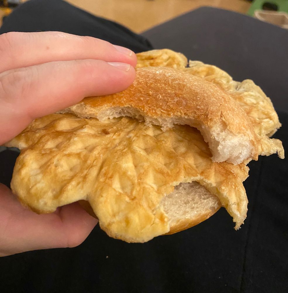 Ein angebissenes Brötchen, darauf eine Waffel