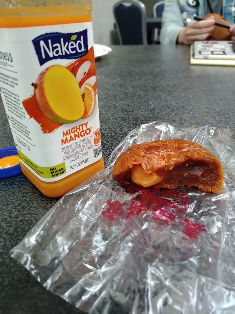 Bottle of mango juice and a half mooncake