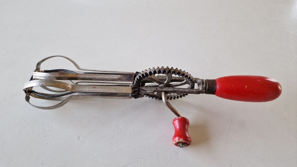 Mechanisch betriebenen Handrührgerät für das Aufschlagen von Flüssigkeiten. Die Griffe sind aus Holz.