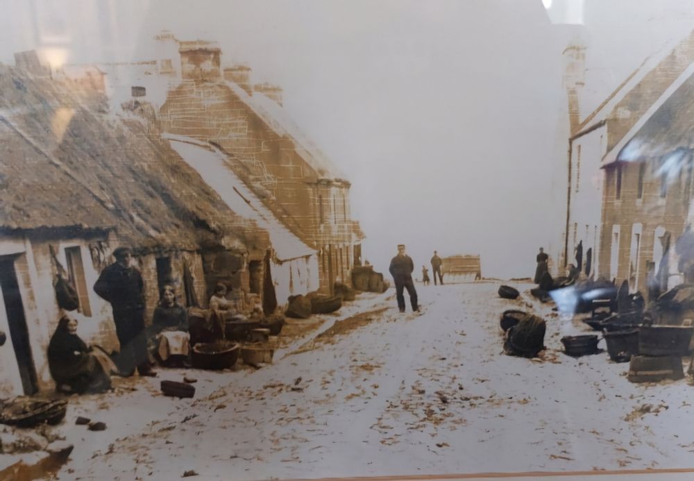 Man standing in a street of old buildings, sepia coloured photo