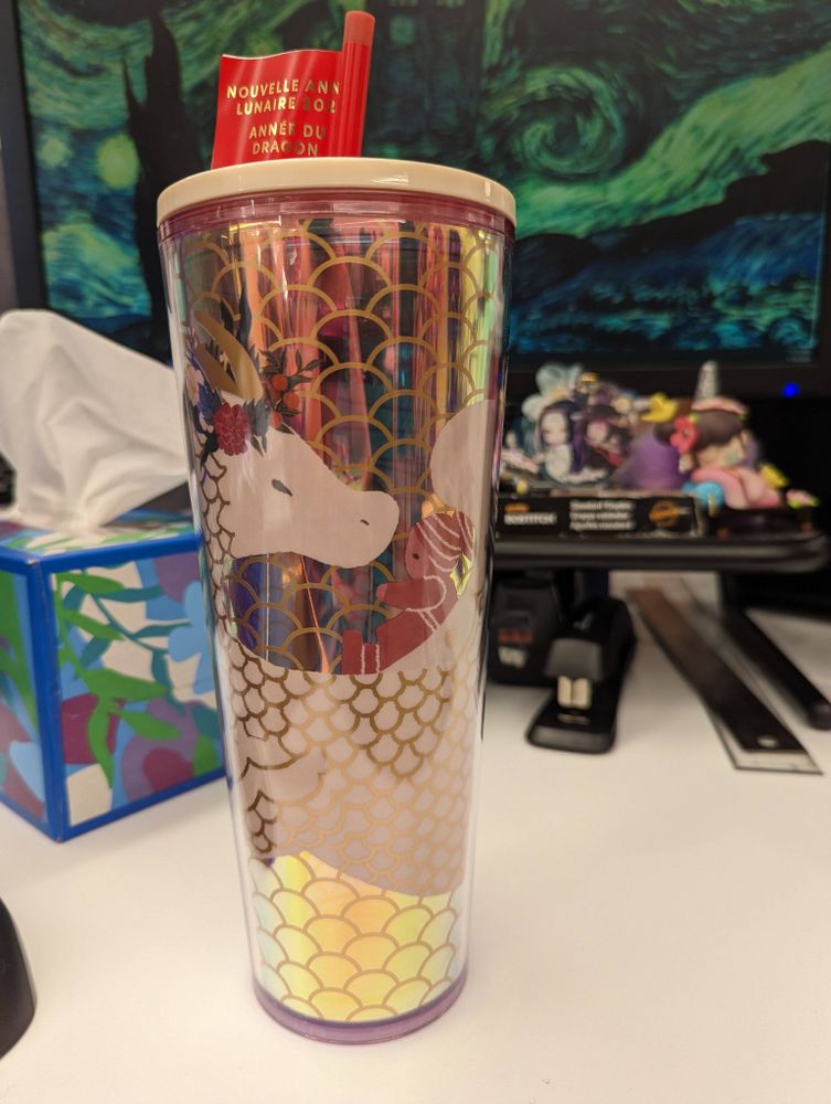 Photo of Starbucks cold drink 2024 Lunar New Year cup. Iridescent scales background with a white winged dragon in the foreground.