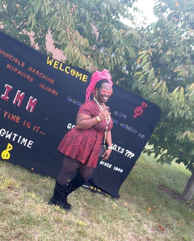 Thick beautiful black woman in a red leopard print dress and neon pink hair 