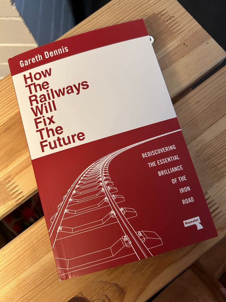 Photograph of book, How The Railways Will Fix The Future by Gareth Dennis, on a wooden side table. 