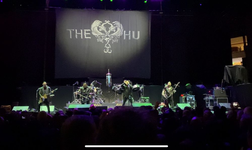 The Mongolian rock band The Hu on stage with a simple banner with the band’s name
