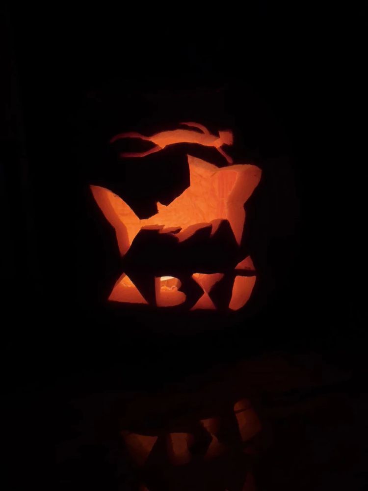 A jack-o-lantern with a scene from the game ABZU showing a diver holding onto a shark and the letters A-B-Z-U carved below it.