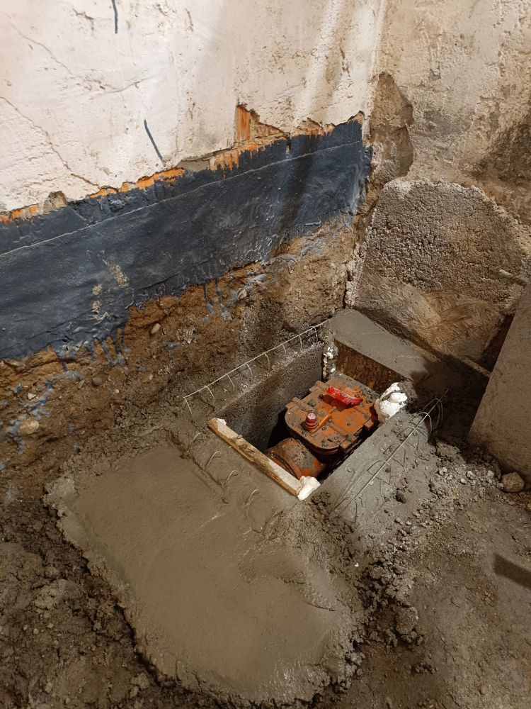 A wastewater pipe leading through fresh concrete