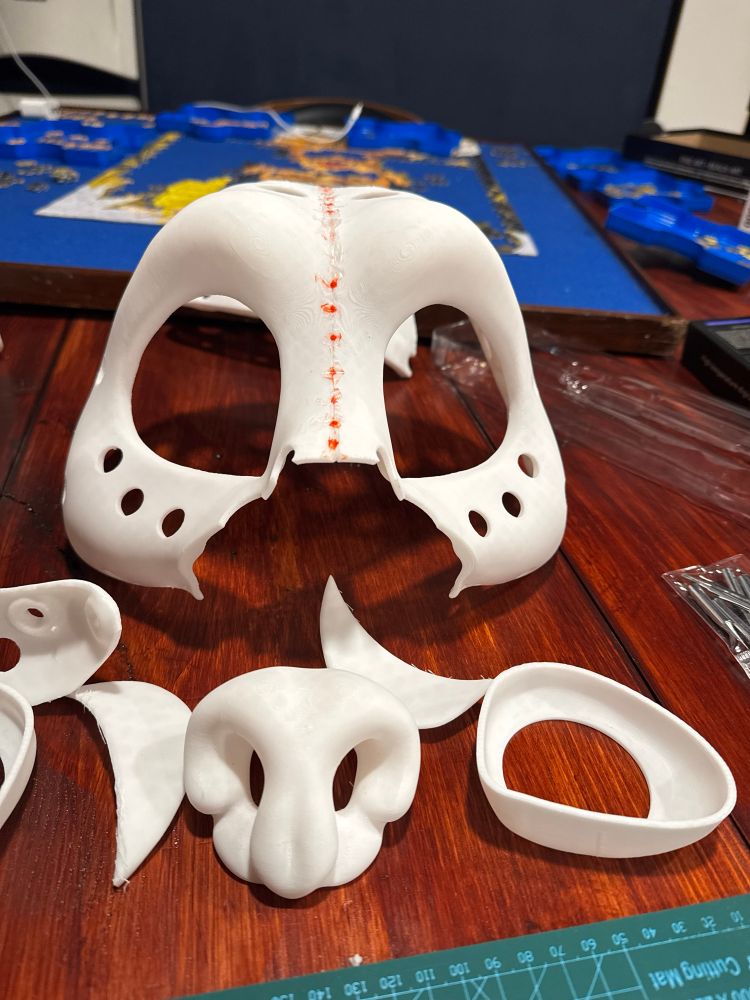 3D printed fursuit bear head in parts on a table. 