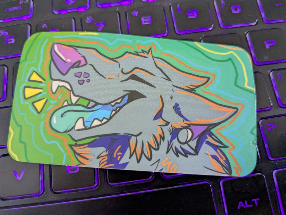 a sticker of a grey wolf that is barking with its tongue out